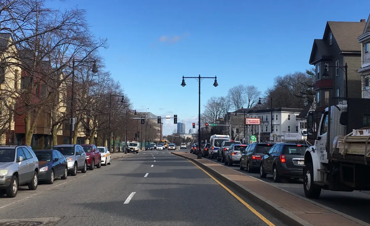 Hyde Park Avenue looking north toward Forest Hills, with four travel lanes and cars parked on both sides