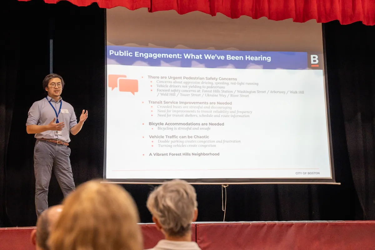 A City of Boston staff member presenting a slide summarizing residents’ pedestrian, transit, bicycle, and traffic concerns